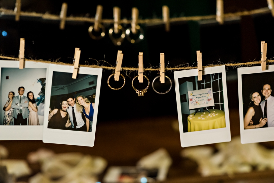 Wedding rings pinned to a string in between wedding polaroids.